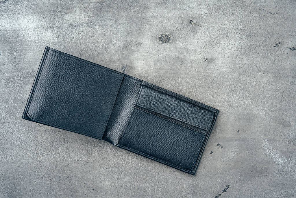 Чорний шкіряний гаманець на сірому бетонному фоні
 - Фото, зображення