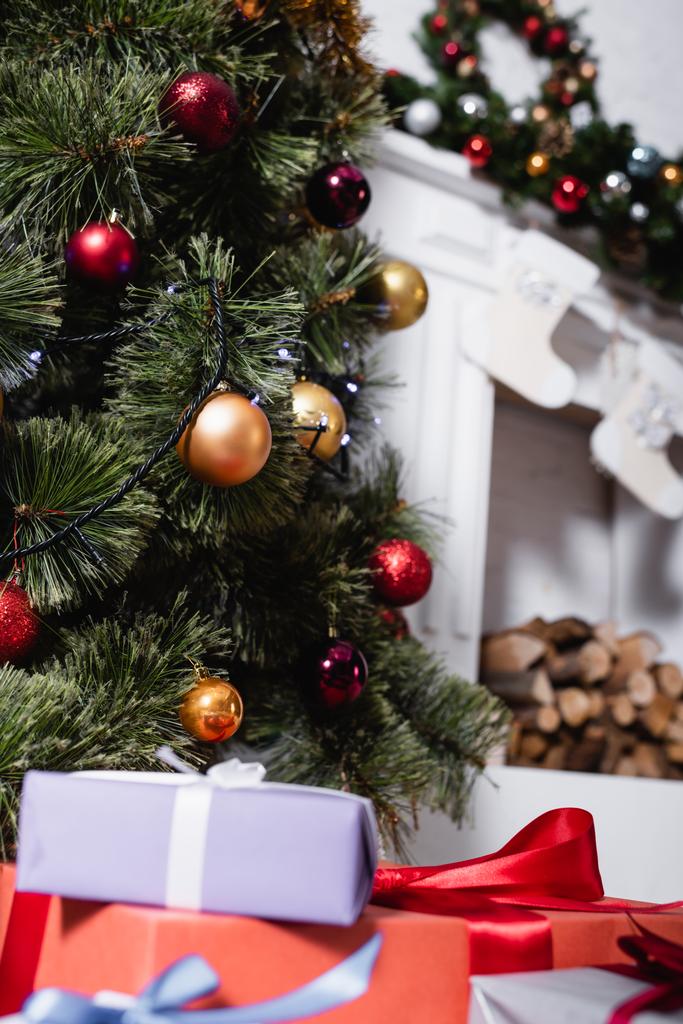 Valikoiva painopiste lahjapakkaukset lähellä koristeltu mänty joulupallot - Valokuva, kuva