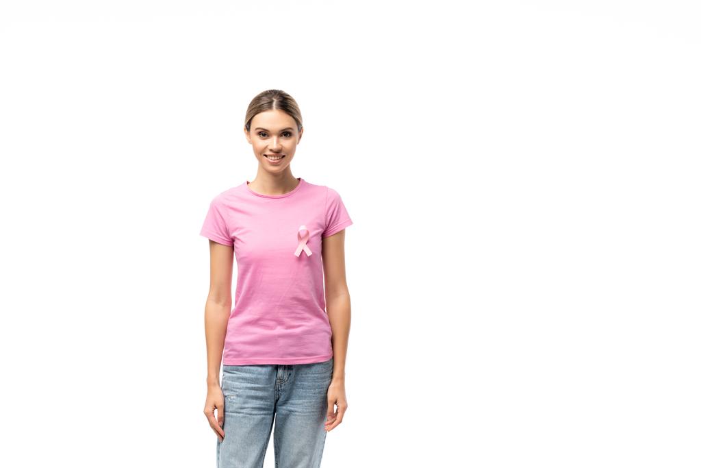 Jeune femme en t-shirt rose avec ruban de sensibilisation au cancer du sein regardant la caméra isolée sur blanc - Photo, image