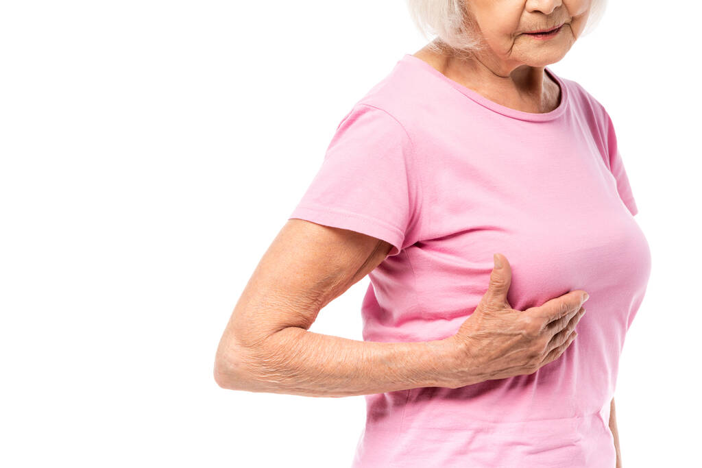 Ausgeschnittene Ansicht einer Seniorin, die ihre Brust isoliert auf weißem Grund berührt, Konzept von Brustkrebs  - Foto, Bild