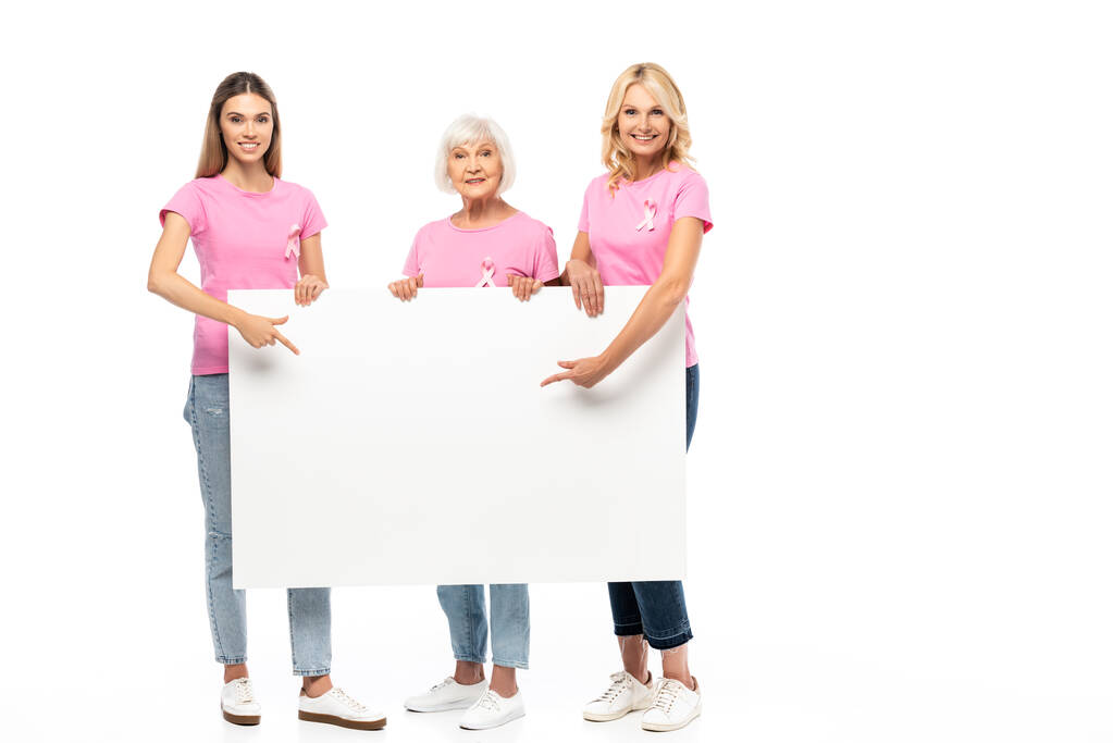 Mujeres con cintas de conciencia sobre el cáncer de mama apuntando a una pizarra vacía sobre fondo blanco - Foto, imagen