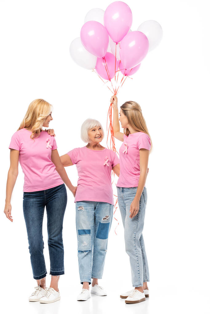 Γυναίκες με μπαλόνια διαφήμιση κορδέλες του καρκίνου του μαστού ευαισθητοποίηση αγκαλιάζει σε λευκό φόντο - Φωτογραφία, εικόνα