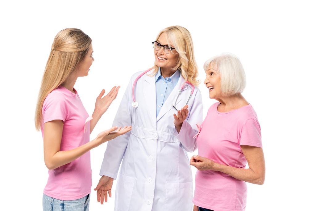 Tシャツの上にピンクのリボンを持つ若い女性は白い上に隔離された医師の近くの手で指す - 写真・画像
