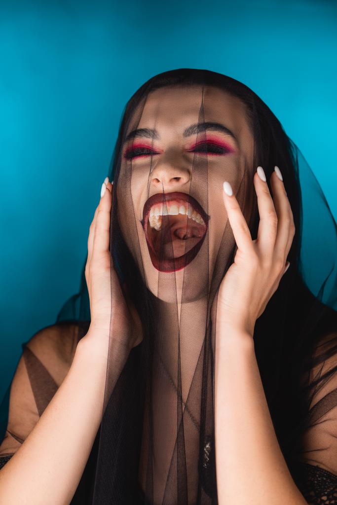 evil bride with black makeup and veil laughing on blue - Photo, Image