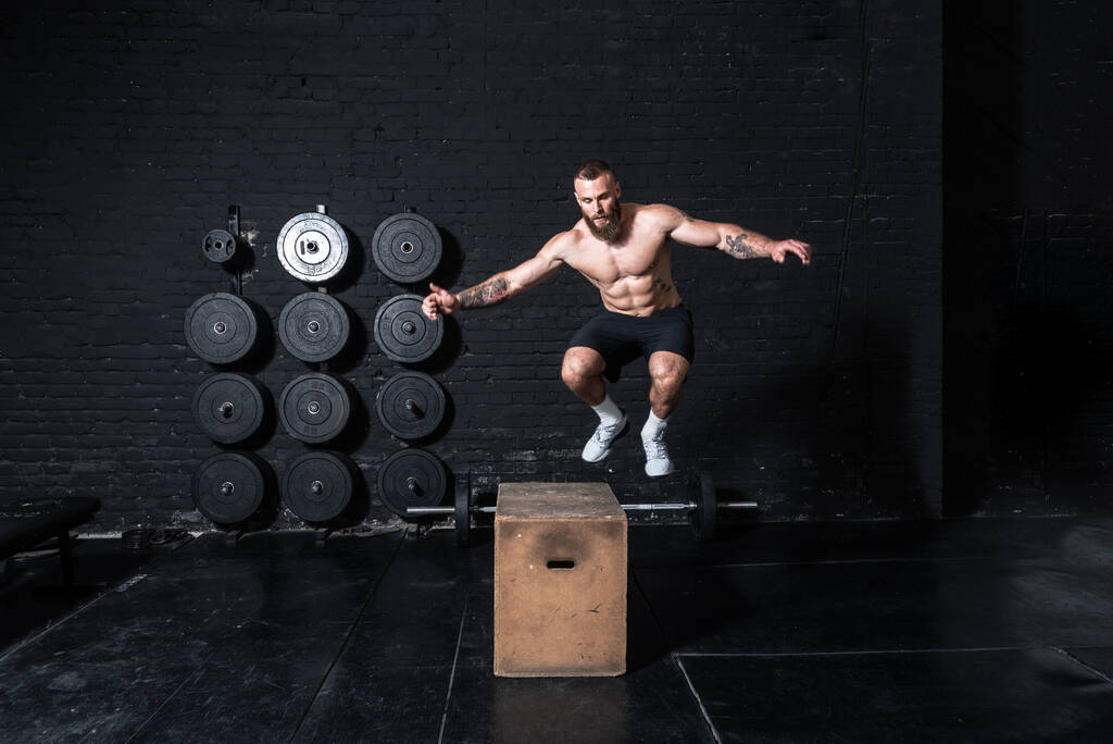 Mladý silný bez košile pocení fit svalnatý muž s velkými svaly dělat box skok hardcore cross cvičení školení v tělocvičně skuteční lidé - Fotografie, Obrázek