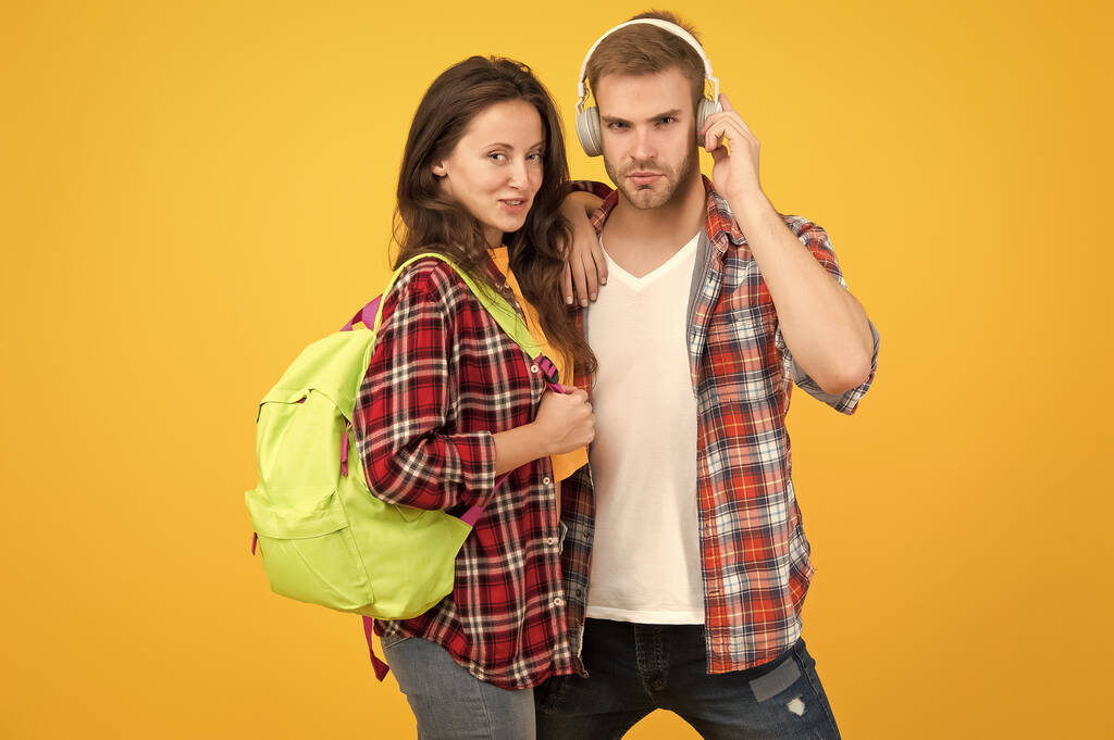 Modern couple wearing matching outfits. Family look concept. Shopping day. Trendsetters. Youth lead way in fashion ideas. Hipster couple students. Fashionable students couple yellow background - Photo, Image