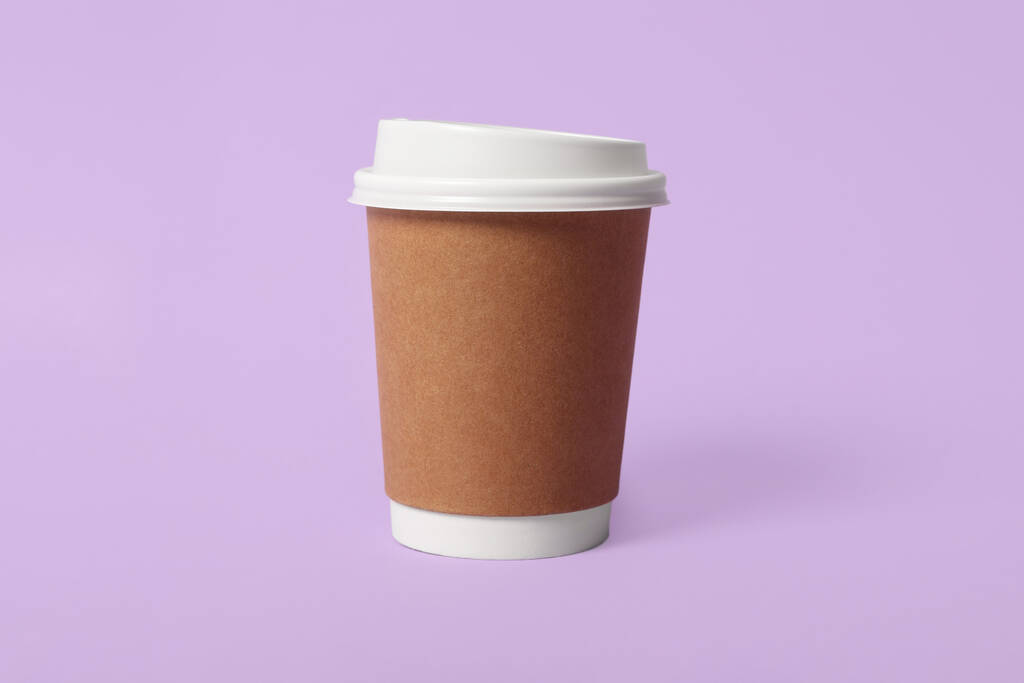 Na wynos papierowy kubek kawy na fioletowym tle - Zdjęcie, obraz