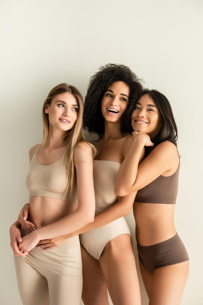 heureux interracial modèles en sous-vêtements souriant tout en posant isolé sur blanc - Photo, image