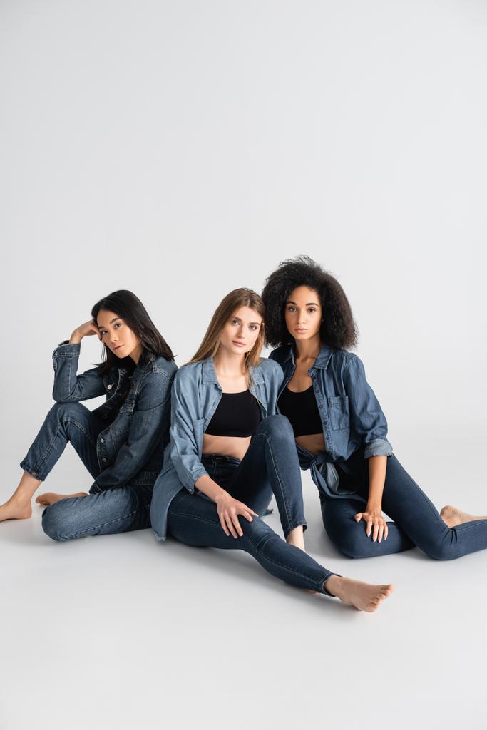 junge interrassische Frauen im Jeans-Outfit posieren auf weiß - Foto, Bild