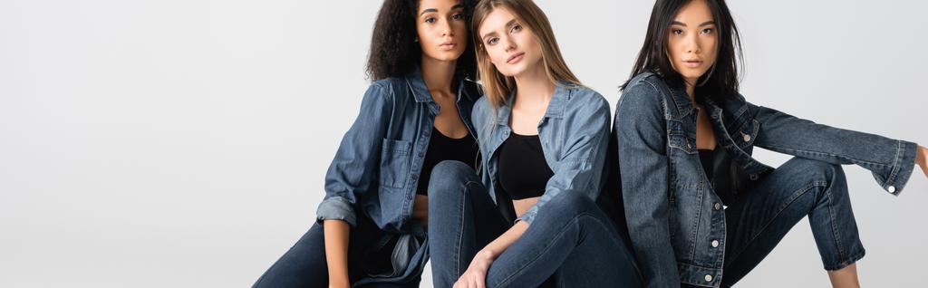 junge interrassische Frauen im Jeans-Outfit posieren isoliert auf weißem Banner - Foto, Bild