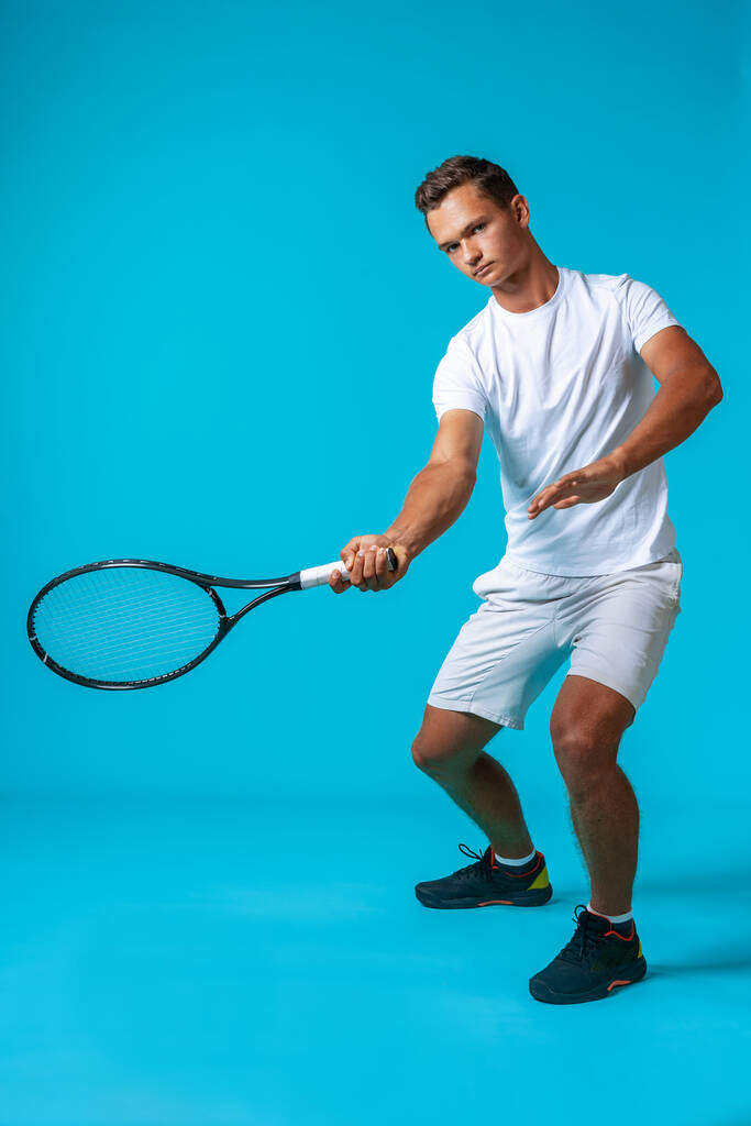 Full length studio portrait of a tennis player man on blue background - Photo, Image