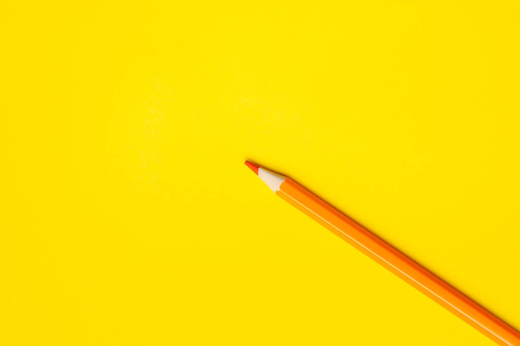 diagonal orange sharp wooden pencil on a bright yellow background, isolated, copy space, mock up - Photo, Image