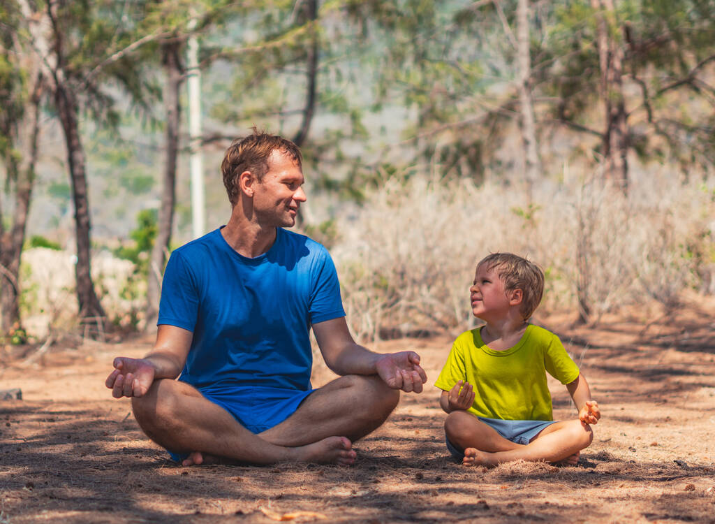 Père médite yoga pose dans le parc forestier sur l'air frais, fils répète, souriant regard heureux à l'autre. Papa influence sur la vision du monde des garçons. Relation de paternité. Les enfants imitent le comportement Enfance - Photo, image