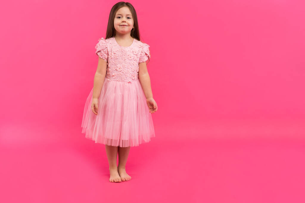Linda niña sueña con convertirse en una bailarina. Pequeña bailarina. Studio Shoot sobre fondo rosa - Foto, Imagen