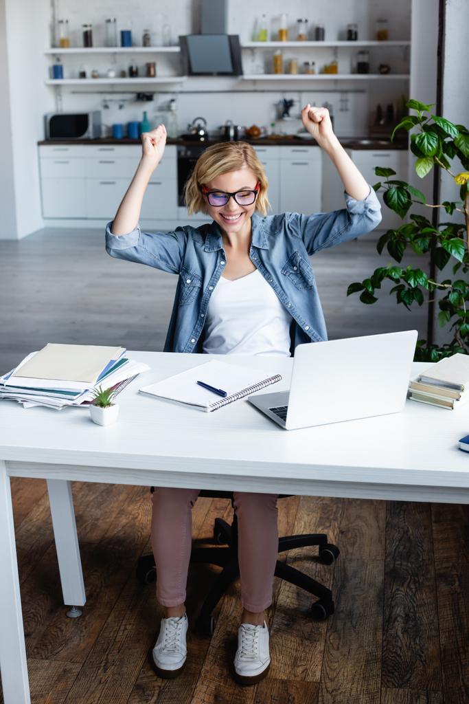 young blonde woman in eyeglasses happy with raised hands - Photo, Image