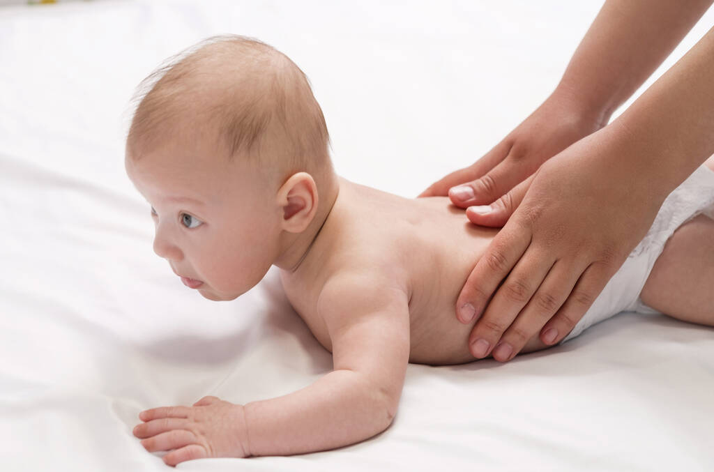 babamasszázs, közelkép kezek a baba hátán - Fotó, kép