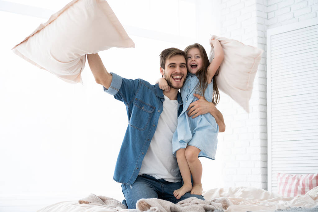 glücklich Vater und Tochter spielen Kissenschlacht im Bett am Morgen - Foto, Bild