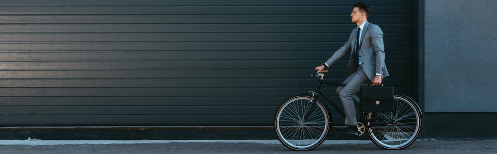 Nuori liikemies jolla salkku ajettaessa polkupyörällä ulkona, banneri  - Valokuva, kuva