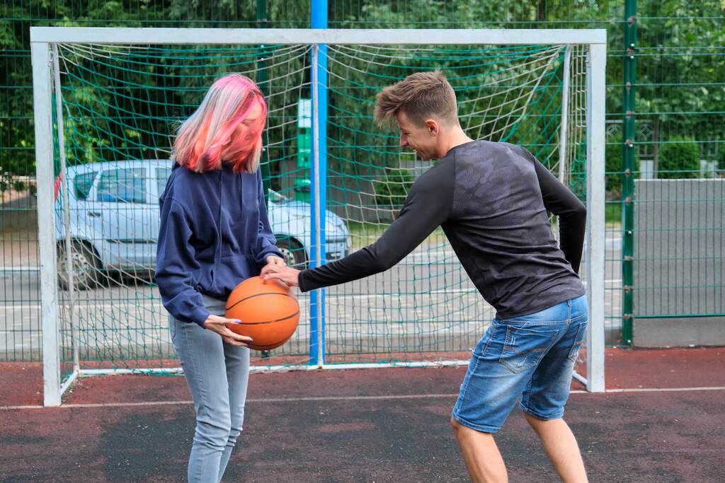 nastolatki chłopiec i dziewczyna grać w koszykówkę ulicy razem - Zdjęcie, obraz