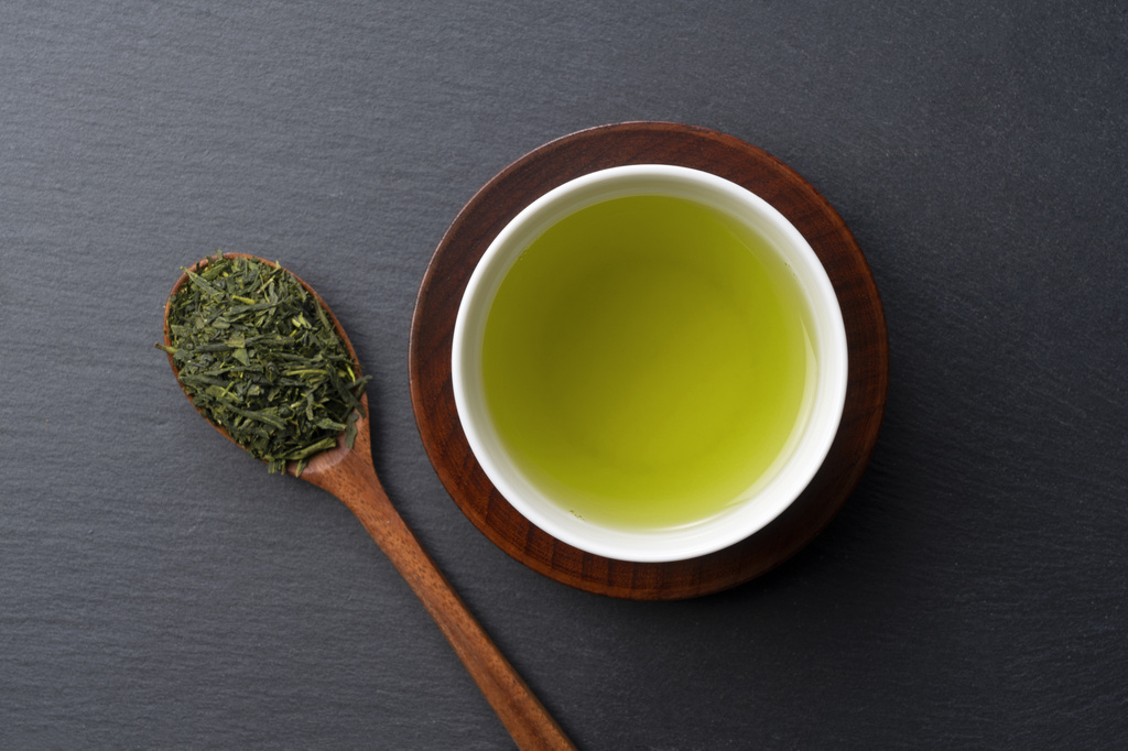 Green Tea for Metabolism. A bird's-eye view of green tea placed on a black background with space. Image of Japanese green tea. - Photo, Image