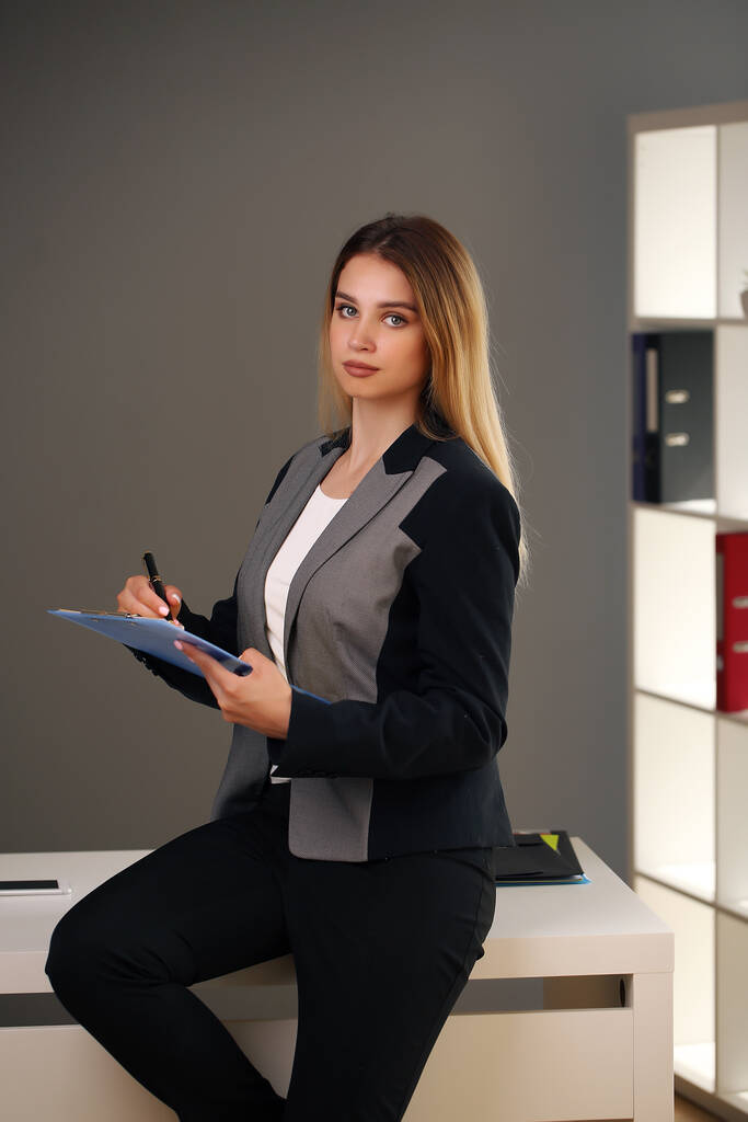 молодая красота в офисе и куртка с документами - Фото, изображение
