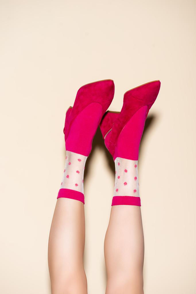 cropped view of female legs in pink retro socks and shoes on beige background - Photo, Image