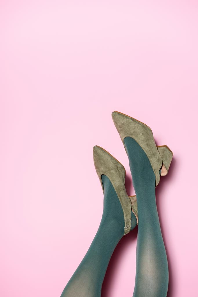 vue recadrée des jambes féminines en collants verts et chaussures rétro sur fond lilas - Photo, image