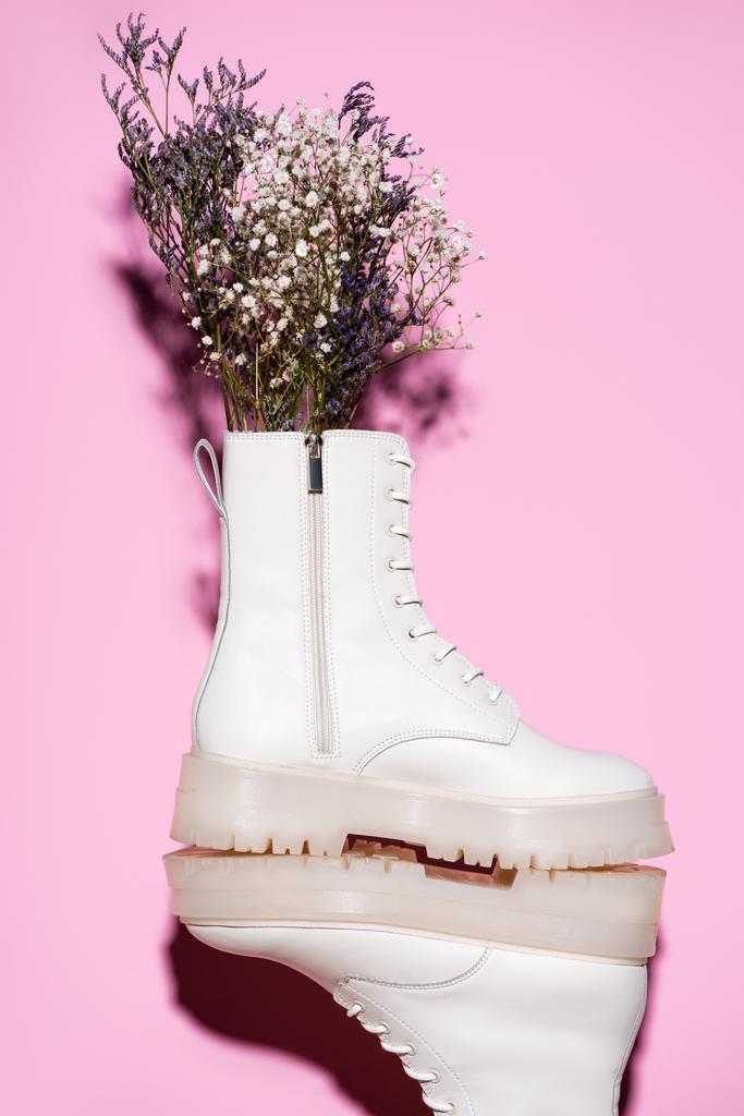 white boots with wildflowers on pink background - Photo, Image