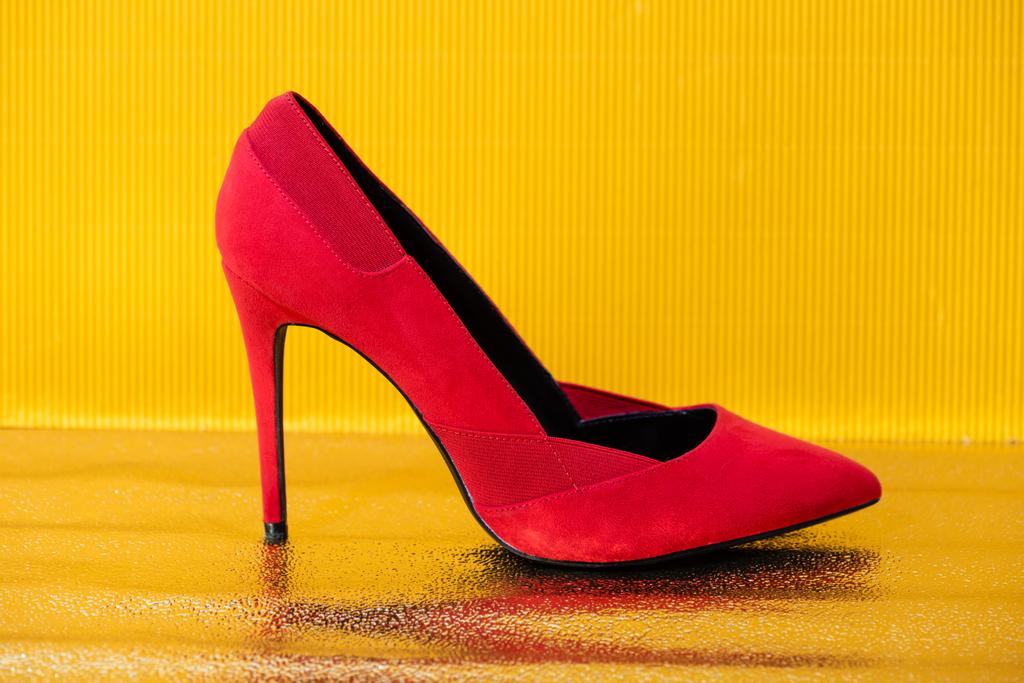 κομψό κόκκινο suede τακούνι παπούτσι σε κίτρινο φόντο - Φωτογραφία, εικόνα