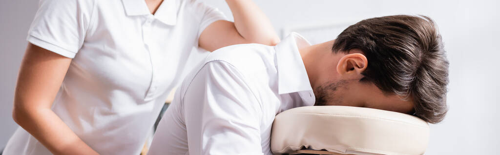 Masseuse doet rug massage met elleboog voor klant, banner - Foto, afbeelding