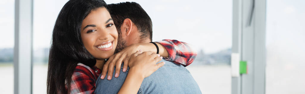 happy african american woman hugging man in airport, banner - Photo, Image
