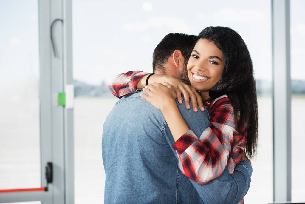 alegre afro-americana mulher abraçando namorado no aeroporto - Foto, Imagem