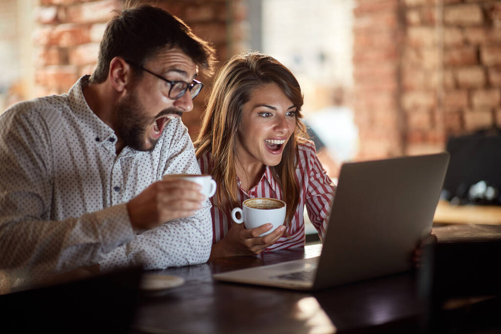 Young couple excited watching a match on the laptop  - Photo, Image