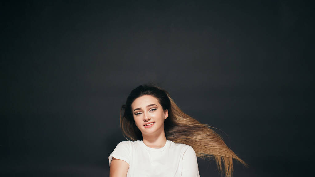 bella giovane donna con i capelli lunghi sdraiato su sfondo nero studio, felice studente ragazza vista dall'alto, concetto di successo - Foto, immagini