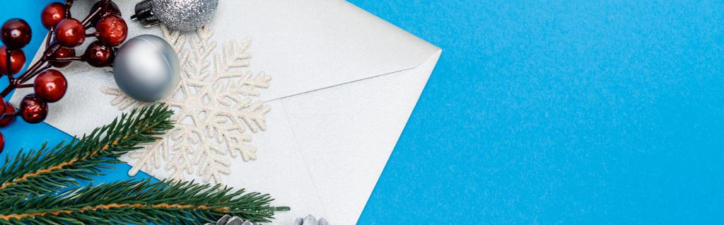 вид зверху сніжинка, срібні вафлі, ягоди, ялина та конверт на синьому фоні, банер
 - Фото, зображення