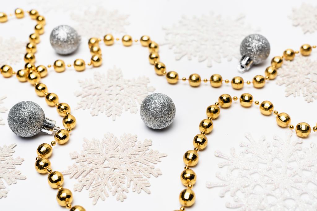 ασημένια και χρυσή χριστουγεννιάτικη διακόσμηση με νιφάδες χιονιού σε λευκό φόντο - Φωτογραφία, εικόνα