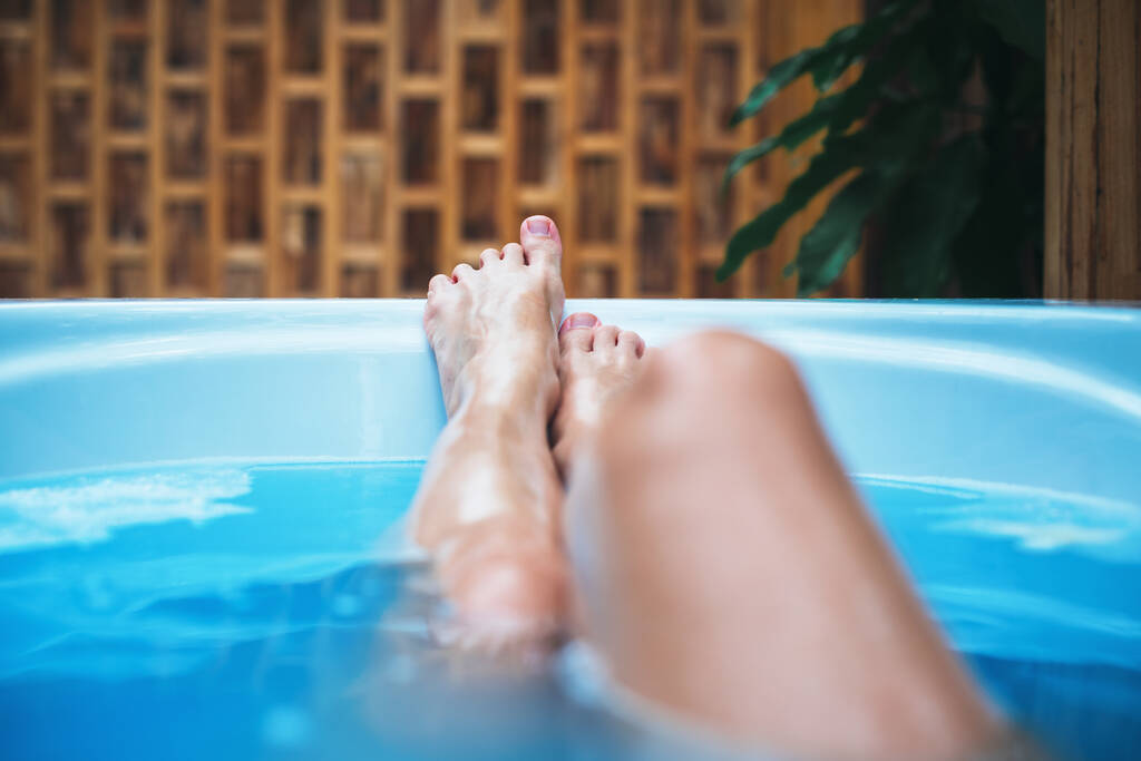 Emelt lábú nő a fürdőkádban. Egészségügyi és SPA eljárás. Fürdőkezelés. Jólét, relaxációs koncepció. Szabadtéri üdülőszálloda - Fotó, kép