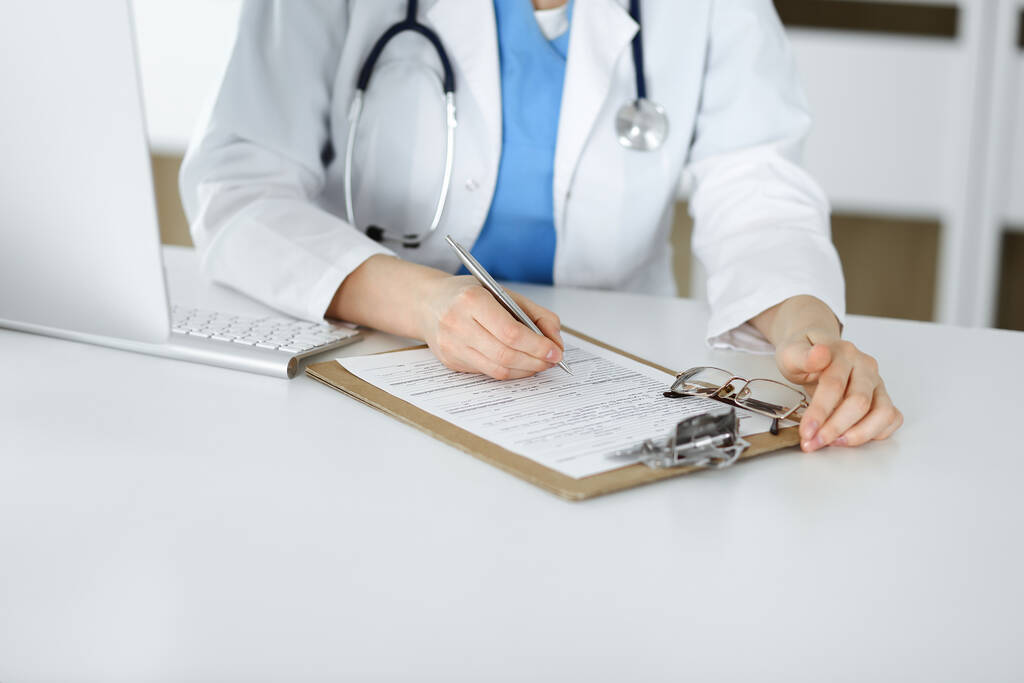 Mulher-médico desconhecido no trabalho preenchendo formulário de registro de histórico de medicação na clínica, close-up da área de transferência - Foto, Imagem