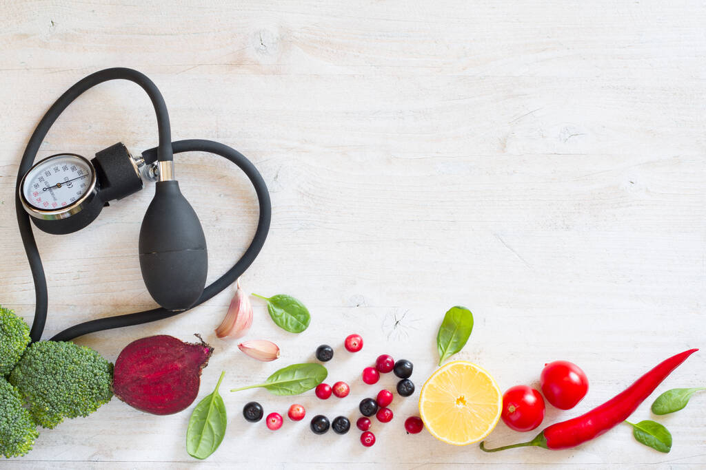 Cardiofrequenzimetro e verdure con frutta per prevenire l'ipertensione, concetto di dieta sana - Foto, immagini