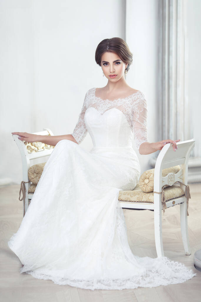 Elegant brunette bride sitting in the hall with columns - Photo, Image