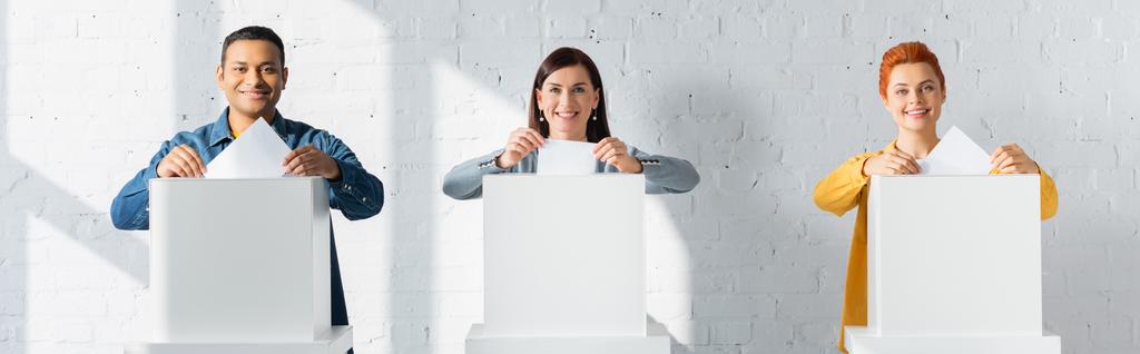 πολυπολιτισμικοί εκλογείς που εισάγουν ψηφοδέλτια σε εκλογικούς θαλάμους, πανό - Φωτογραφία, εικόνα
