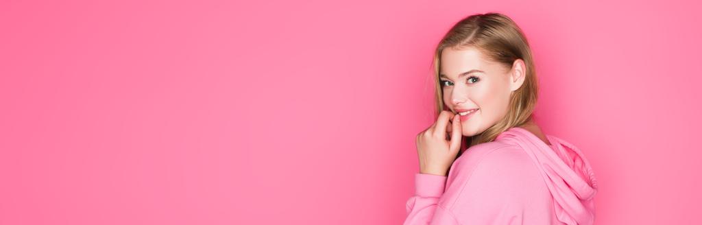 csinos fiatal nő kapucnis mosoly rózsaszín háttér, banner - Fotó, kép