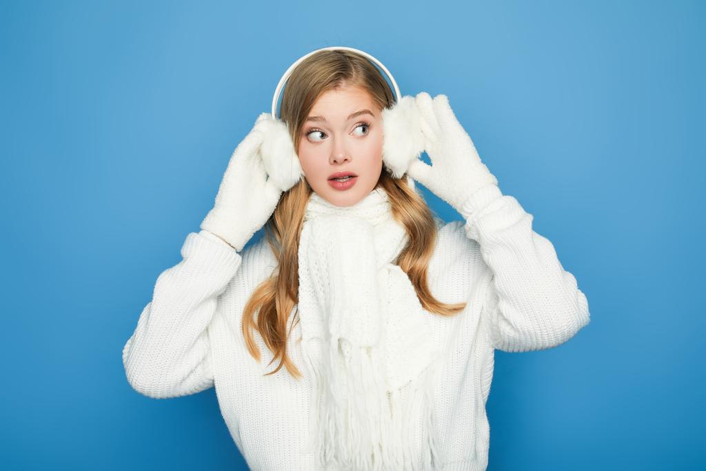 έκπληκτος όμορφη γυναίκα το χειμώνα λευκό στολή που απομονώνονται σε μπλε - Φωτογραφία, εικόνα