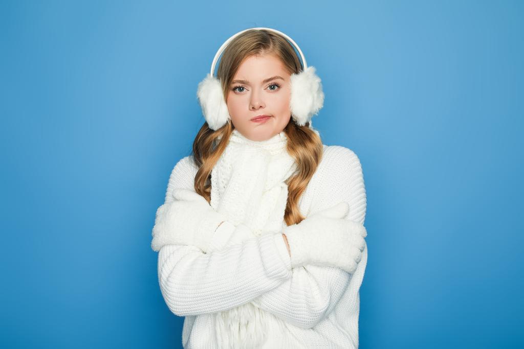 mooie vrouw in de winter wit outfit gevoel koud geïsoleerd op blauw - Foto, afbeelding