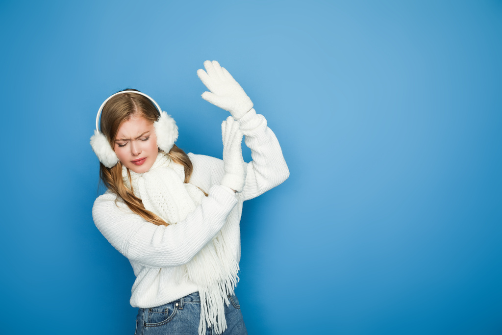 mooie vrouw in de winter witte outfit tonen stop gebaar geïsoleerd op blauw - Foto, afbeelding