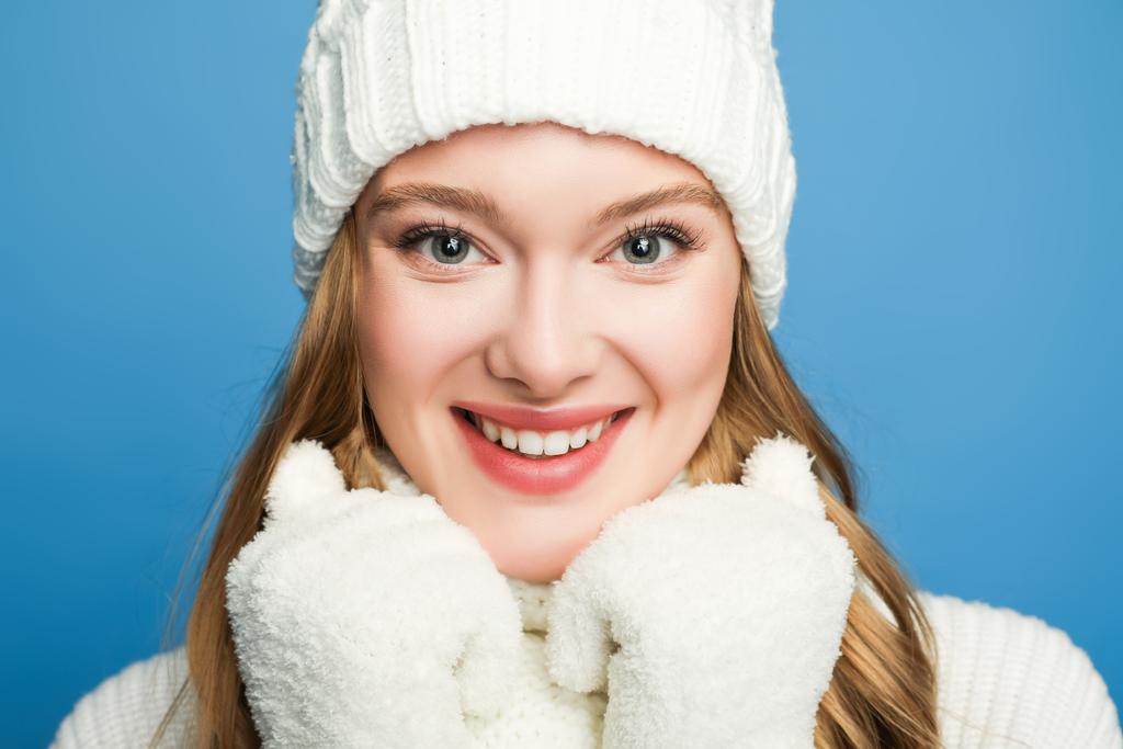 portrait of smiling beautiful woman in winter white outfit isolated on blue - Photo, Image