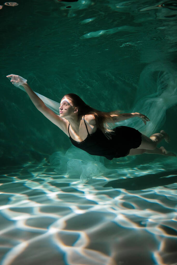 Joven chica delgada bajo el agua con un paño. Magia del agua. Fotografía submarina. Art. - Foto, Imagen