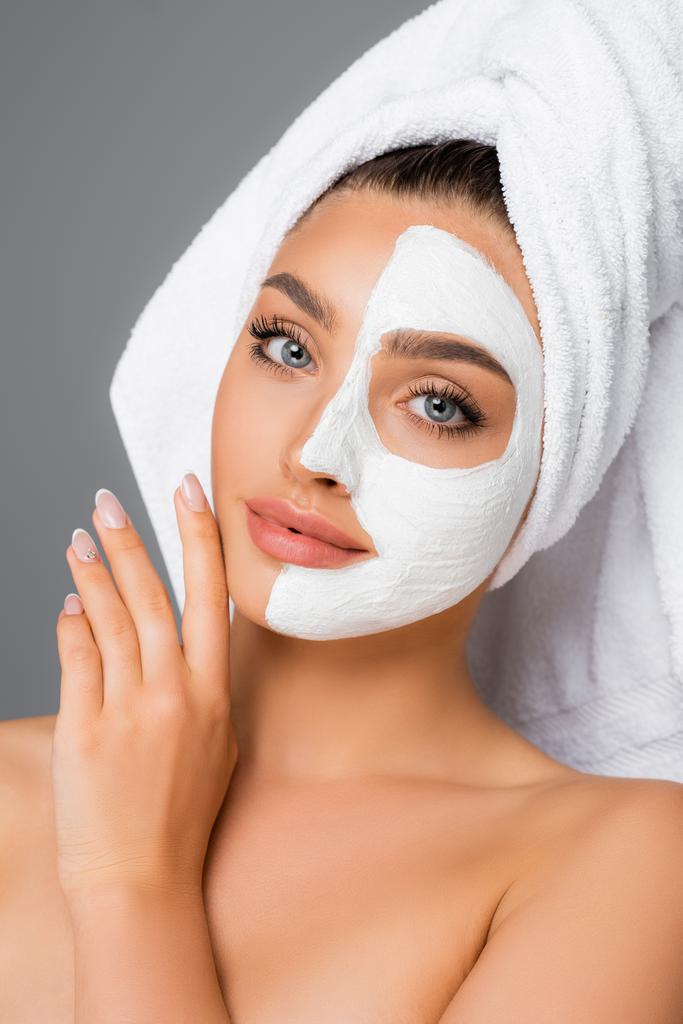 woman with towel on head and clay mask on face isolated on grey - Photo, Image