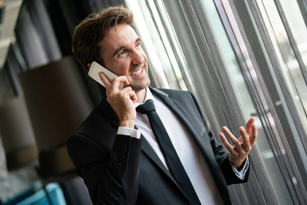 Exitoso empresario feliz utilizando el teléfono móvil en la oficina. Negocios, tecnología, concepto de personas - Foto, Imagen