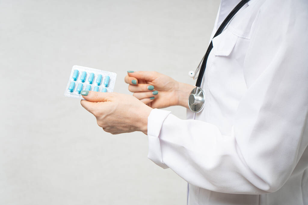 Η γιατρός κρατάει ένα πιάτο χάπια στα χέρια της..  - Φωτογραφία, εικόνα